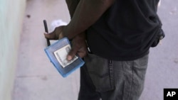 Un hombre sostiene su libreta de abastecimiento en una tienda del gobierno en La Habana.