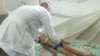 Un médico diagnostica a un niño en medio de un brote de dengue, en Colón, Matanzas. (Captura de imagen/Girón)
