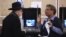 Un votante habla con una trabajadora de un colegio electoral de Nueva York después de depositar su voto en las elecciones de 2016 en EE.UU.