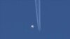 En esta foto proporcionada por Brian Branch, un gran globo se desplaza por encima de la zona de Kingstown, Carolina del Norte, mientras por debajo se observa un avión y la estela que deja a su paso. (Brian Branch vía AP)
