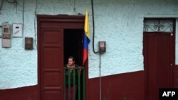 Una mujer espera el paso del presidente Iván Duque, de visita en Amaga, Antioquia, el pasado 8 de septiembre.