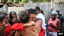 Marlon Brando Díaz (C), encarcelado por su participación en las protestas antigubernamentales de julio de 2021, saluda a sus familiares después de ser liberado de la prisión en el barrio de Guinera en La Habana el 16 de enero de 2025.  YAMIL LAGE / AFP