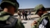 Un agente del Instituto Nacional de Inmigración (INM) habla con cubanos luego de ser detenidos por la Guardia Nacional de México mientras intentaban cruzar ilegalmente la frontera entre los Estados Unidos y México, en Ciudad Juárez. Foto Archivo