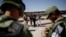 Un agente del Instituto Nacional de Inmigración (INM) de México habla con cubanos detenidos por la Guardia Nacional mientras intentaban cruzar ilegalmente la frontera en Ciudad Juárez el 21 de junio de 2019 (Archivo).