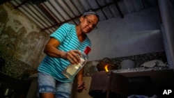 Una cubana cocina alimentos en un fogón de carbón en el Mariel, Cuba. (AP/ Ramón Espinosa)