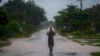 Un hombre usa un trozo de plástico como protección ante las fuertes lluvias provocadas por el huracán Helene, en Batabano, Cuba, el miércoles 25 de septiembre de 2024. (Foto AP/Ramon Espinosa)