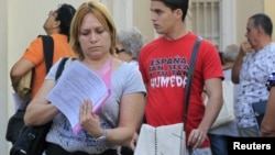 Una cubana revisa sus papeles tras visitar una oficina de inmigración en La Habana, Cuba.