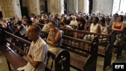 Varias personas participan en una misa.