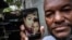 Emilio Román muestra una foto de su hijo Yosney, de 26 años, y su hija Mackyanis, de 24, condenados a 10 años por cargos de sedición por participar en las protestas del 11J. (Foto AP/Ramón Espinosa)