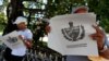 Dos personas leen el Proyecto de Constitución de la República de Cuba.