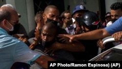 309 / 5000 Resultados de traducción La policía detiene a un manifestante antigubernamental durante una protesta en La Habana, Cuba, el domingo 11 de julio de 2021.
