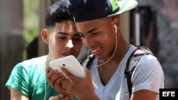 Dos jóvenes navegan por la internet en un dispositivo móvil en una de las zonas habilitadas con Wifi en La Habana (Cuba).