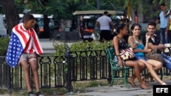 Un joven lleva la bandera de EE.UU. sobre sus hombros en La Habana (Cuba).