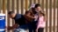 Una familia de inmigrantes cubanos tras cruzar la frontera a Estados Unidos, en Yuma, Arizona. RINGO CHIU / AFP/Archivo)