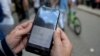 Una mujer chequea las opciones para conectarse a Internet en Cuba. (Yamil Lage/AFP/Archivo)