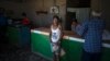 Una mujer compra pan por la libreta de racionamiento en una bodega en San Nicolás, el 19 de mayo de 2023. AP Photo/Ramon Espinosa