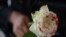 Una mujer sostiene una rosa "ensangrentada" en señal de luto por los feminicidios. (Pedro Pardo/AFP/Archivo)
