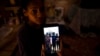 María Carla Milán Ramos muestra una foto en su teléfono de su esposo y hermanos, todos en prisión por participar el 11 de julio del 2021. (AP/Ramón Espinosa).